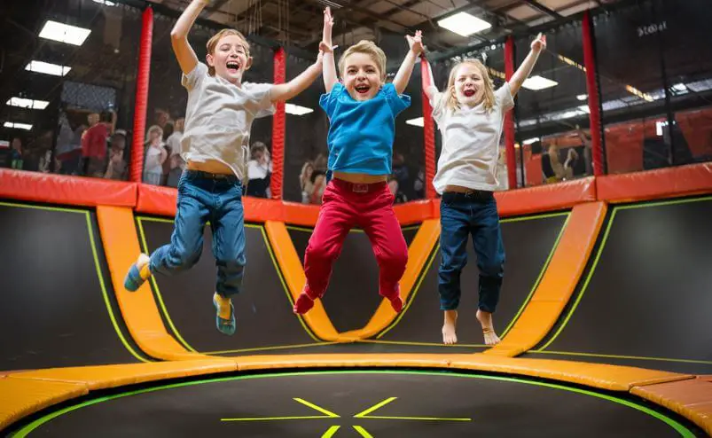3 kids jumping on a trampoline