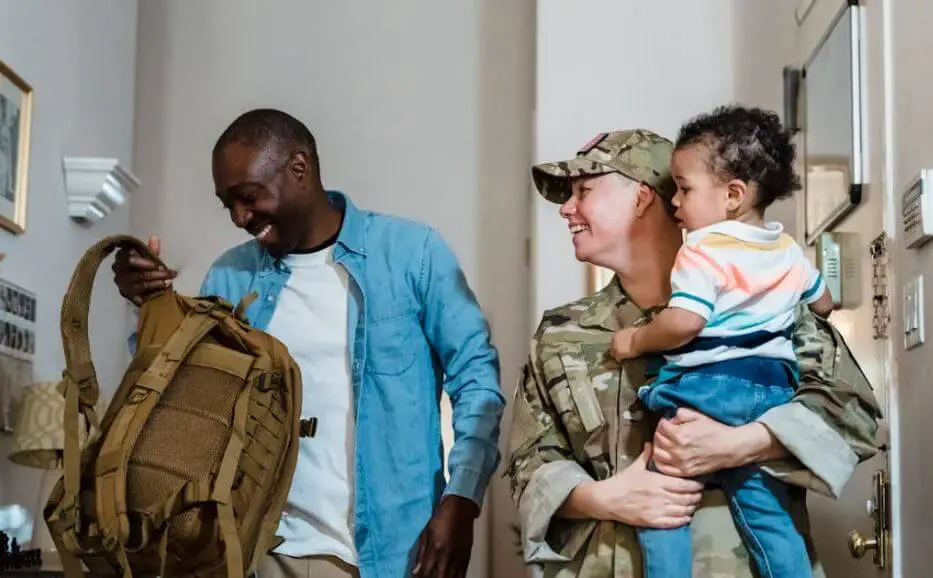 a family with woman in military uniform holding child