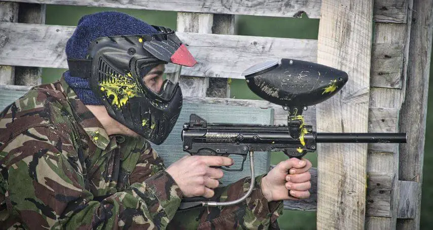 man in camo holding a paintball rifle