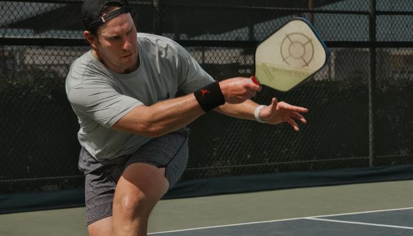 man hitting in pickleball