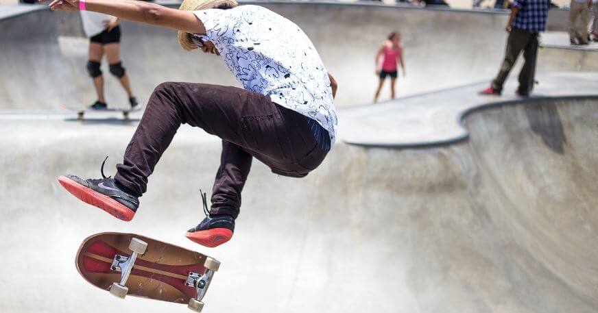young man doing a skateboard trick at a skate park