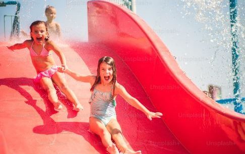 children sliding down a slide at a waterpark